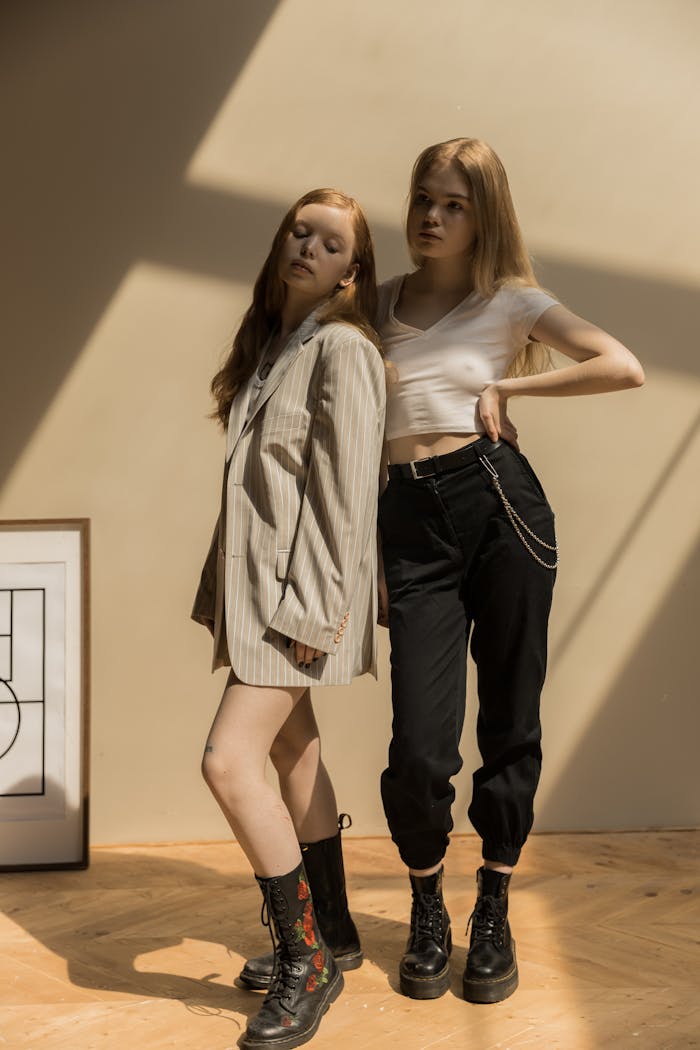 about-01 Two stylish caucasian women in trendy outfits posing indoors with creative shadows.